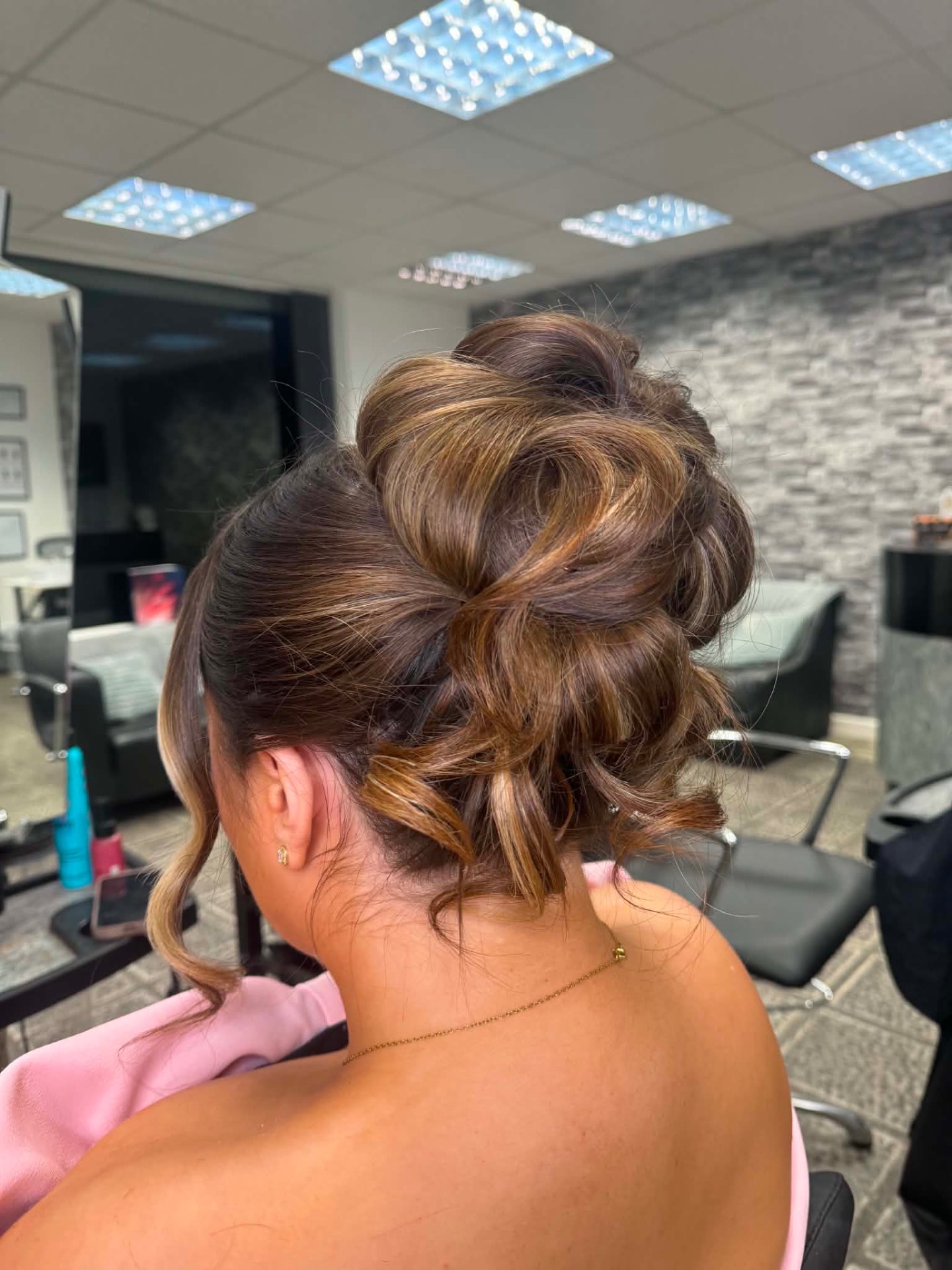 Voluminous brunette updo with curled detail and side strands